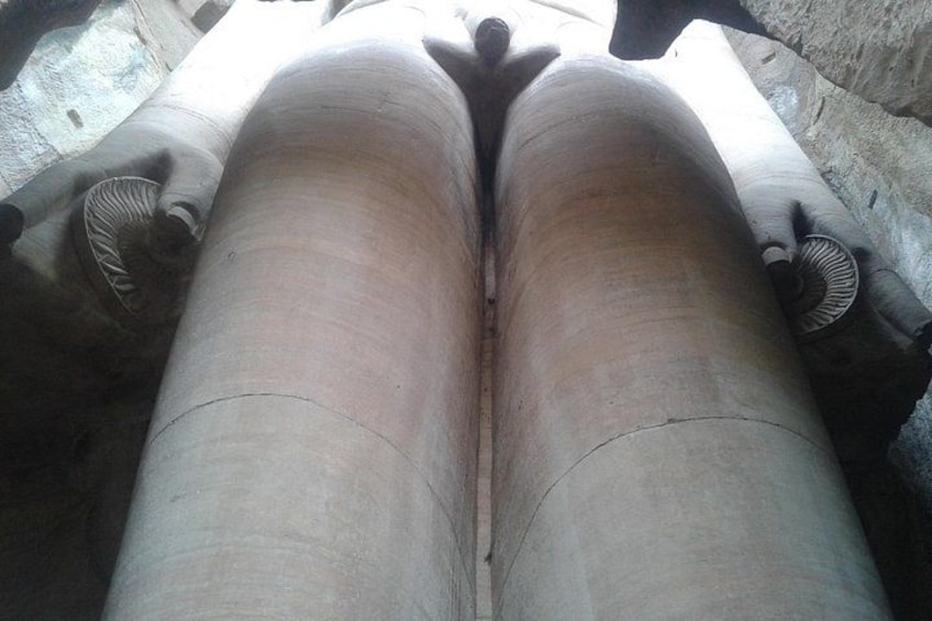 A close-up of a person's legs seated on a bench. 4