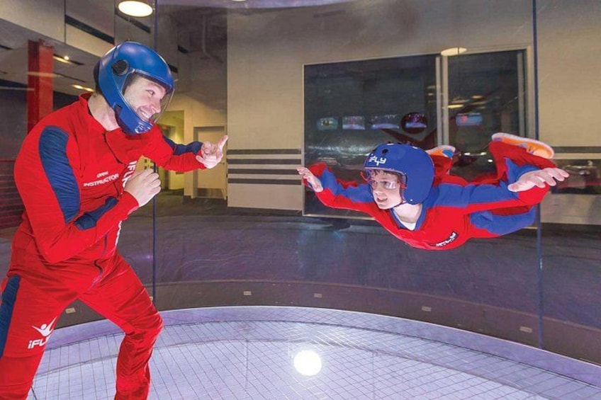Une personne vêtue d’un costume rouge et bleu, portant un casque, et se tenant sur un trampoline. 3