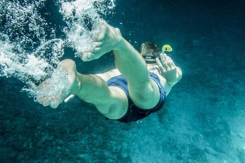 A person swimming underwater with fins and a snorkel. 2