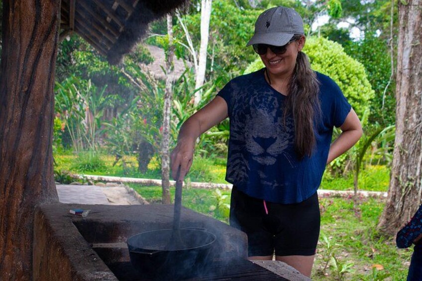 A person cooking outdoors with a large pot on a grill. 2