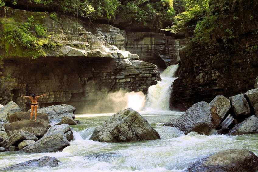 A waterfall, rocky terrain, and a person standing on rocks. 5