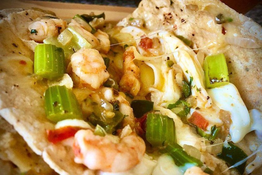 Un plat de fruits de mer composé de crevettes, de légumes et d’une sauce crémeuse, servi dans une tortilla en forme de bol. 2
