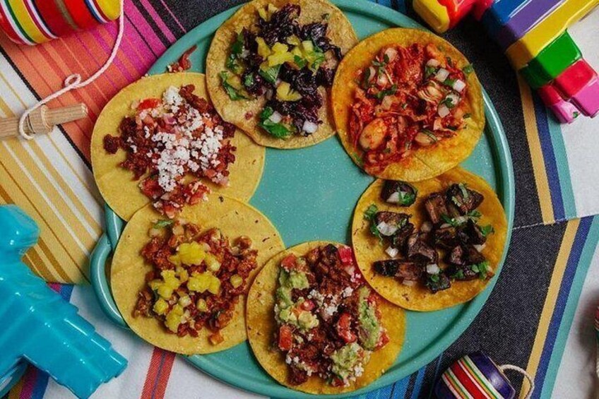 A tray with six tacos, each topped with different ingredients. 5