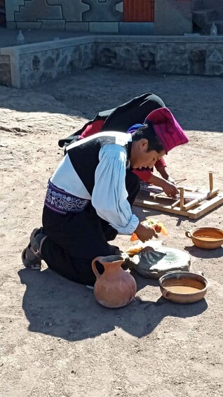 Una persona arrodillada al terra, treballant amb un marc de fusta i una olla de fang. 4