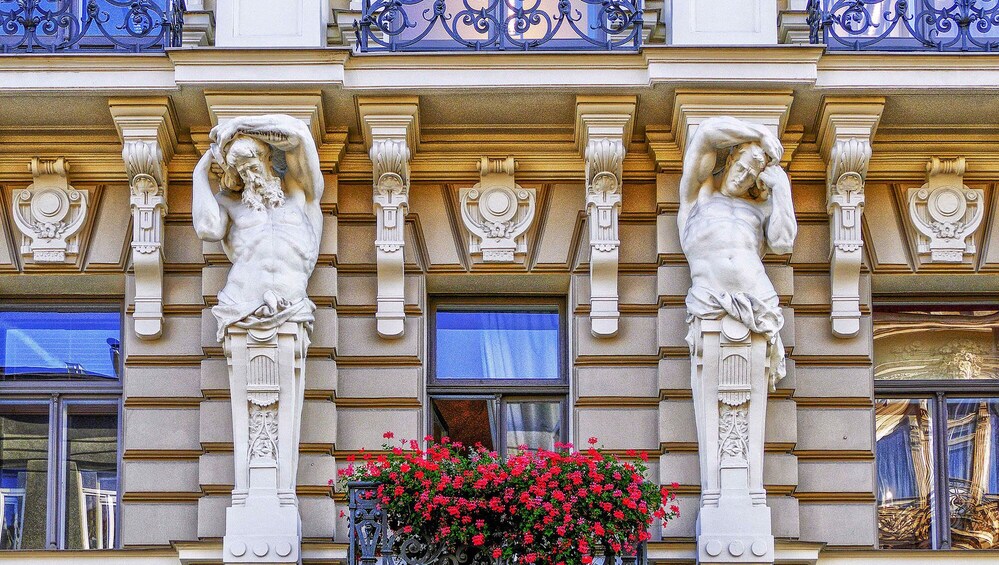 A building facade with ornate sculptures and a flower box. 5