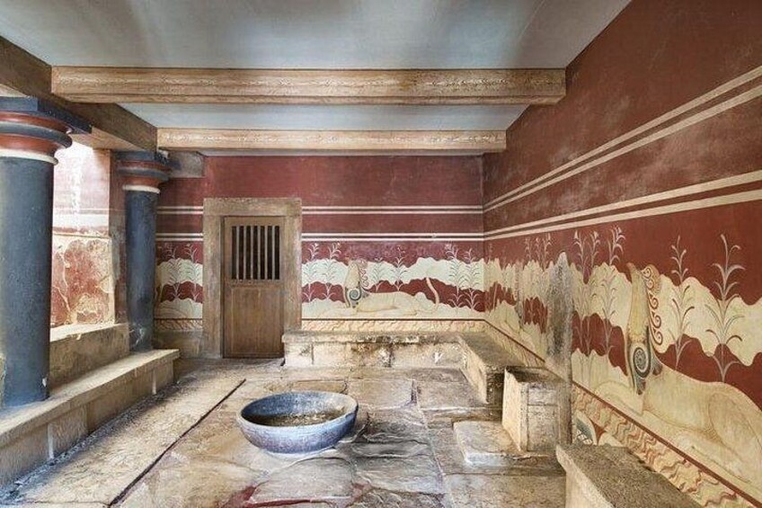 An ancient Roman bath with marble columns, a large basin, and decorative wall paintings. 4