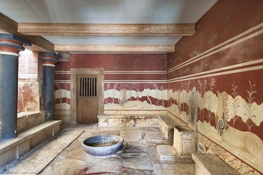 Un antiguo baño romano con columnas de mármol, una gran cuenca y pinturas decorativas en las paredes. 4