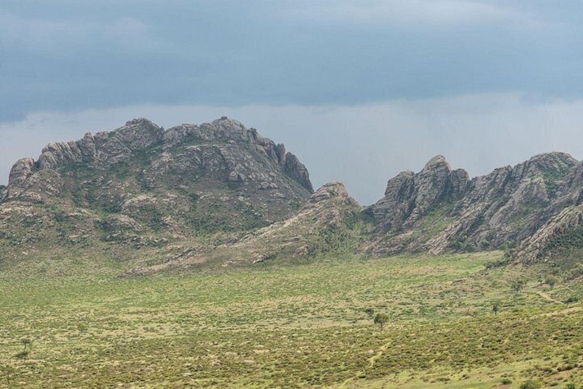 A mountainous landscape with rocky peaks and sparse vegetation. 5