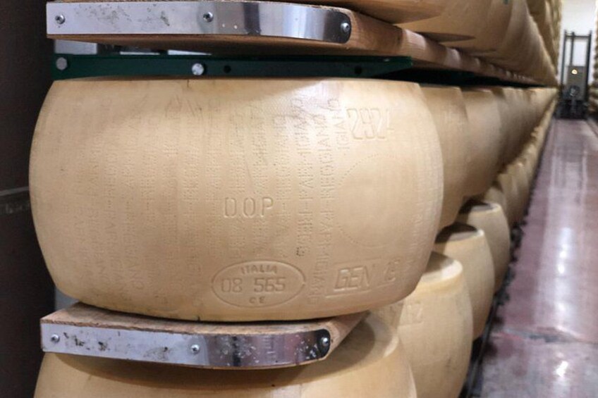 A row of large, cylindrical objects with embossed text and numbers, likely barrels or containers, arranged in a line. 3