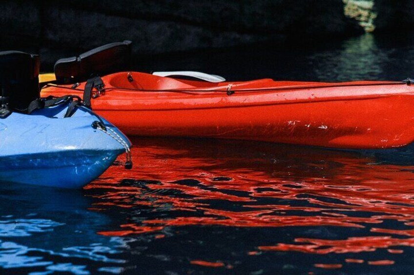 Two kayaks, one red and one blue, docked in calm water. 5