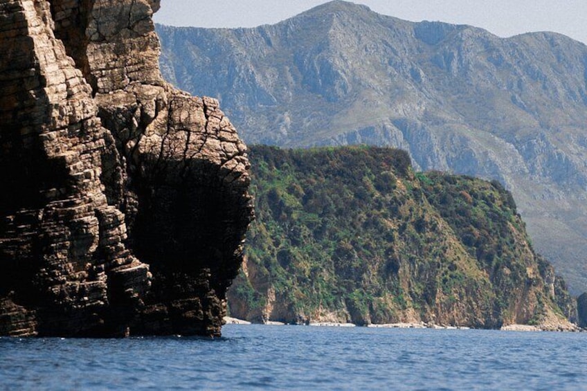Budva Bay Kayak & SUP Tour to Coastal Caves – rugged cliff face and clear coastal waters at the entrance to Pigeon Cave, Montenegro 2