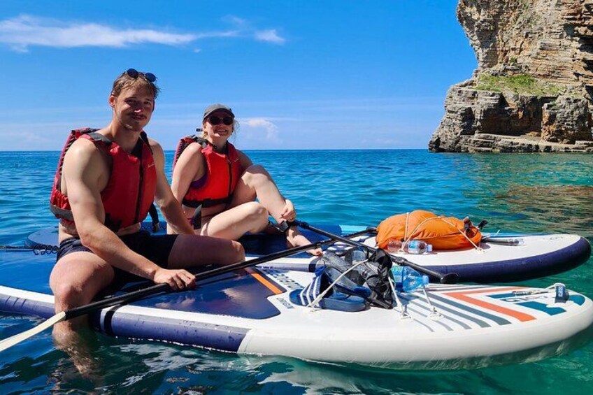 Budva Bay Kayak & SUP Tour to Coastal Caves – two SUP riders smiling on a board in front of Old Town Budva, Montenegro 2