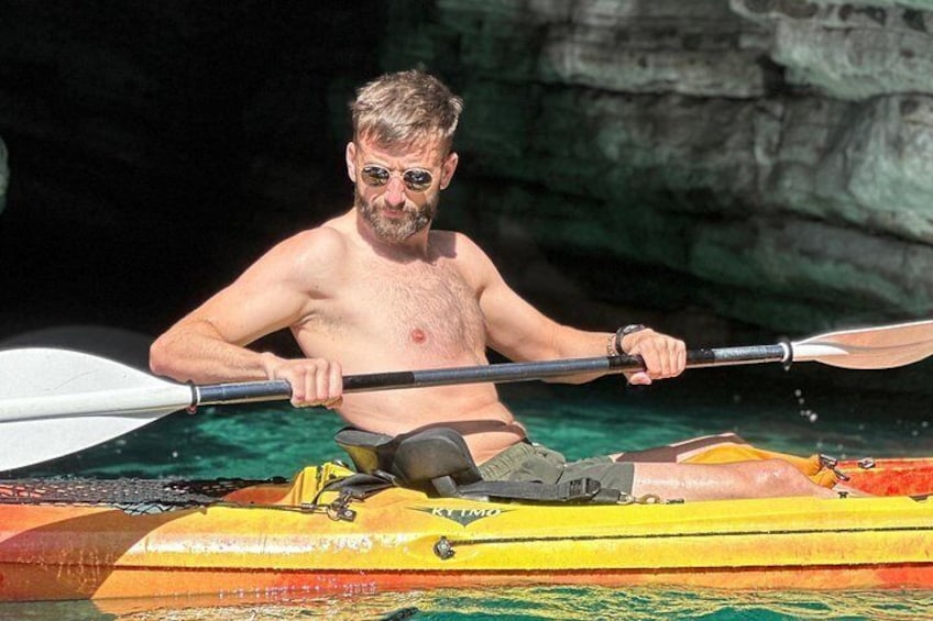 Budva Bay Kayak & SUP Tour to Coastal Caves – man paddling an orange kayak near Pigeon Cave, Montenegro 4