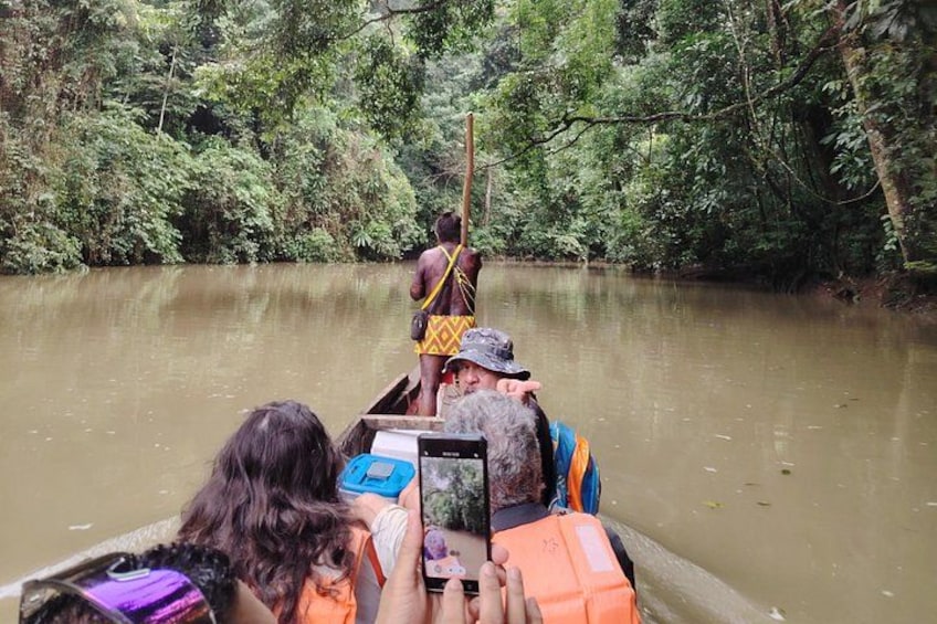 A river with a boat carrying people and a guide. 1