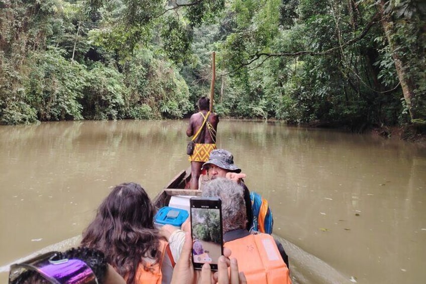 Un río con una barca que transporta gente y un guía. 1