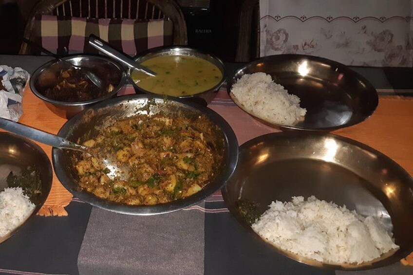 A meal with various dishes including rice, curry, and a green lentil dish on a table. 4