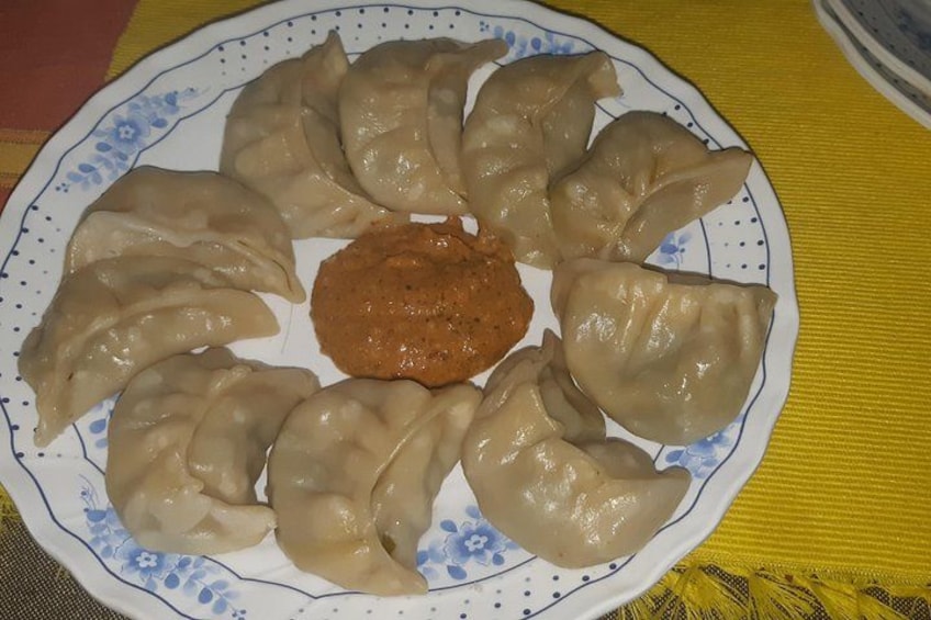 Un plato de dumplings con una cucharada de salsa en el centro. 2