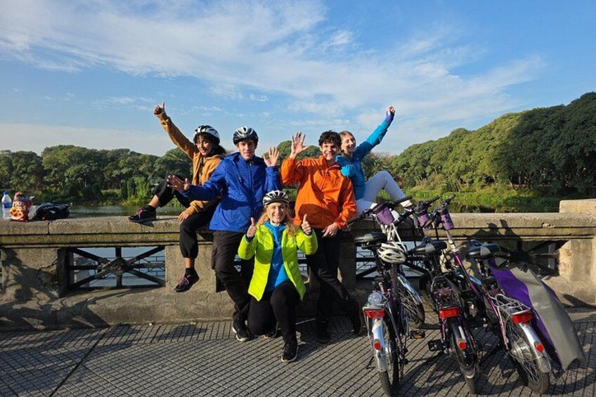A group of people on a bridge with bicycles. 1