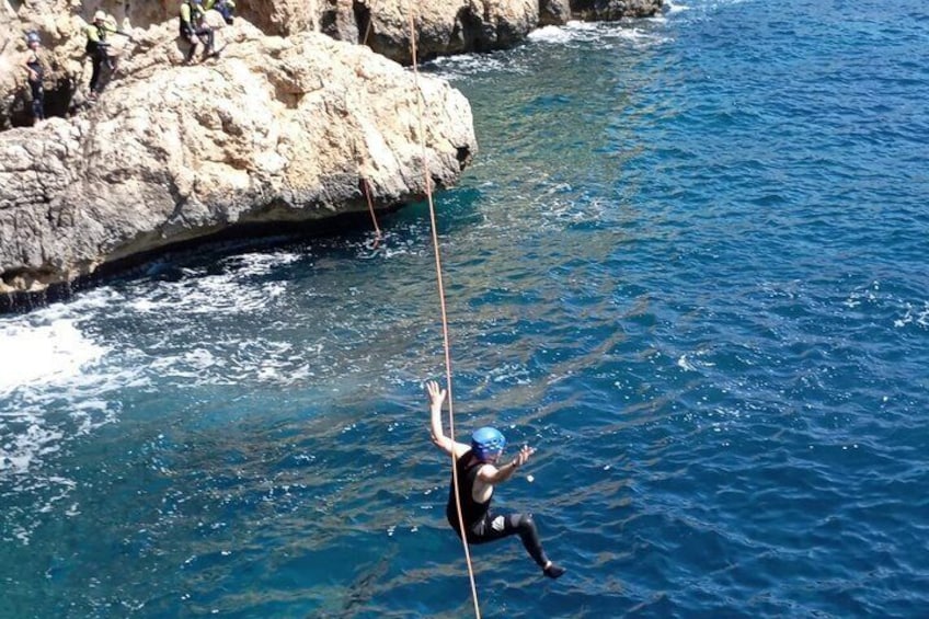 Une personne qui descend en rappel une falaise rocheuse pour atterrir dans une étendue d’eau. 4