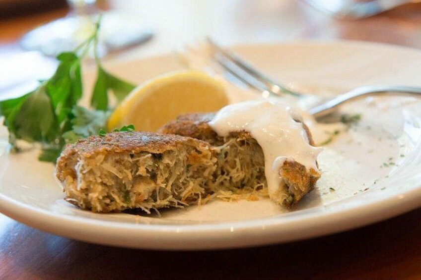 Un piatto con un cibo, un spicchio di limone e una forchetta. 5