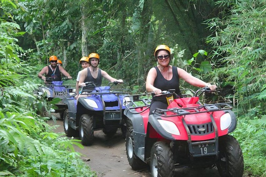 People riding ATVs on a forest trail. 4