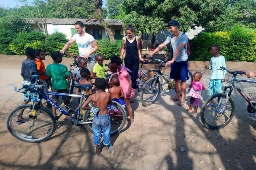 Un groupe d’enfants et d’adultes s’est rassemblé autour de vélos dans un endroit en plein air. 2