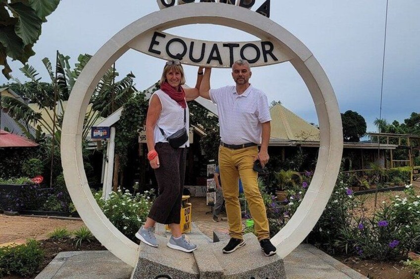 Un segnale circolare con la scritta 'EQUATOR' al centro, circondato da vegetazione e un edificio sullo sfondo. 2