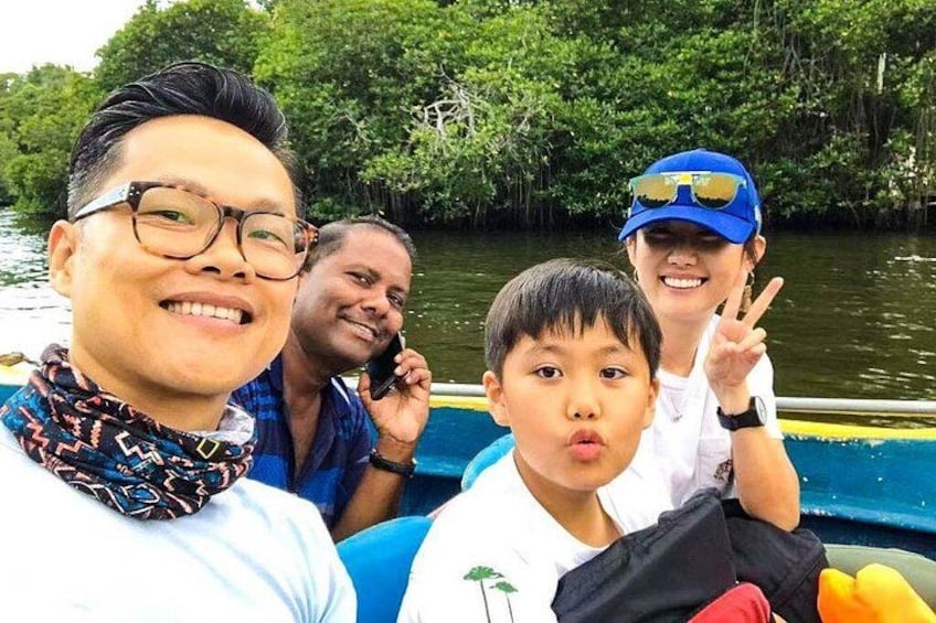 Eine Gruppe von Menschen auf einem Boot, im Hintergrund ein Fluss und Bäume. 4