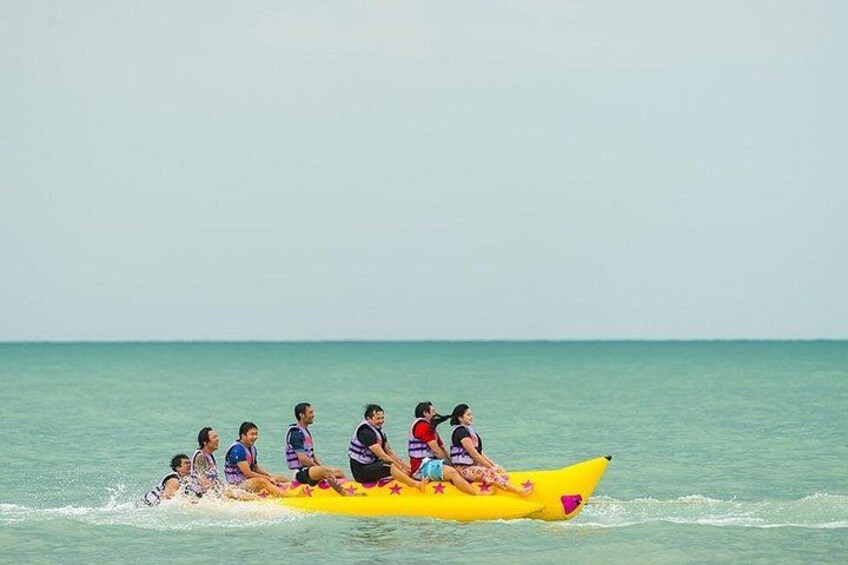 A yellow boat with people rowing on a calm sea. 1
