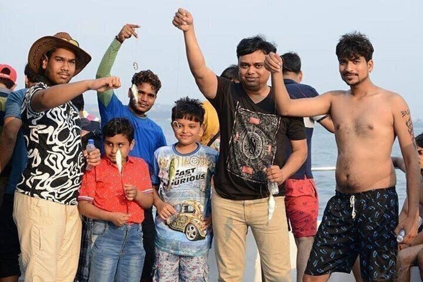 A group of people standing on a beach, some holding hands, with a clear sky in the background. 2