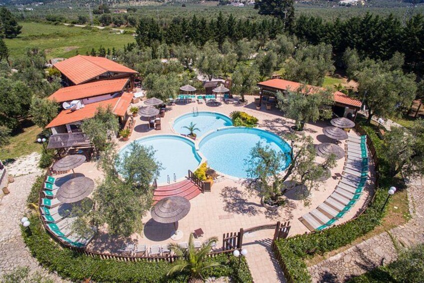 A resort with two swimming pools, lounge areas, and a mountainous backdrop. 4