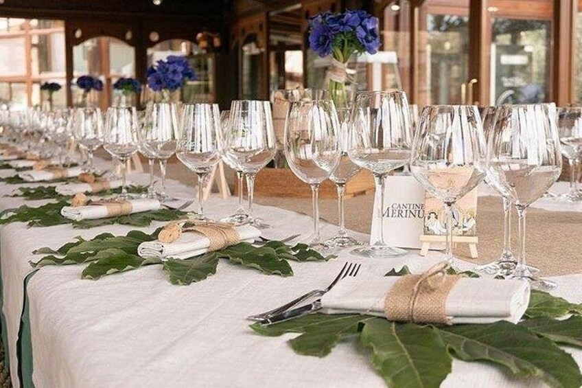 A table set with wine glasses, napkins, and a menu. 2