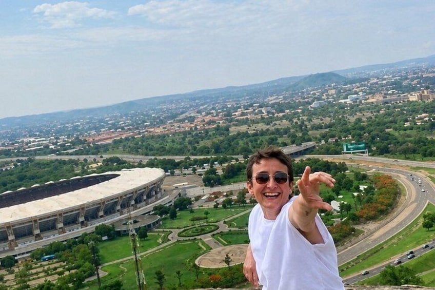 A stadium with a large seating area and a person in a white shirt. 3