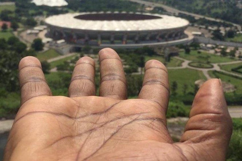 A hand with lines on the palm, with a stadium in the background. 5