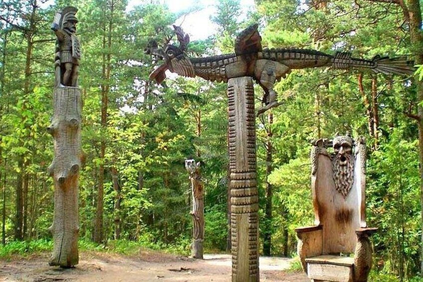 A forest with large, carved stone structures resembling animals and mythical creatures. 5