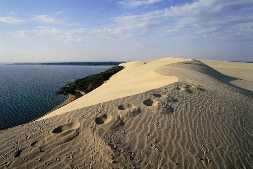 Un paysage désertique avec des dunes de sable et une étendue d’eau. 5