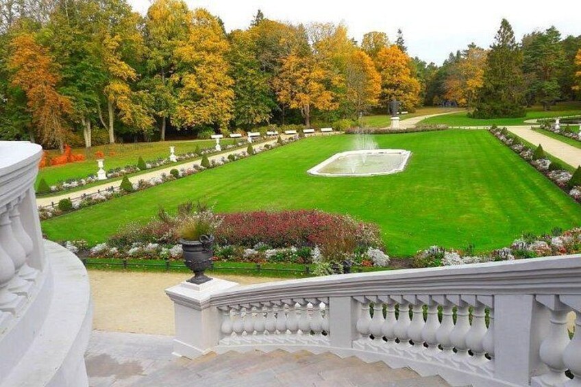 Un jardín ajardinado con césped central, senderos y una fuente. 3