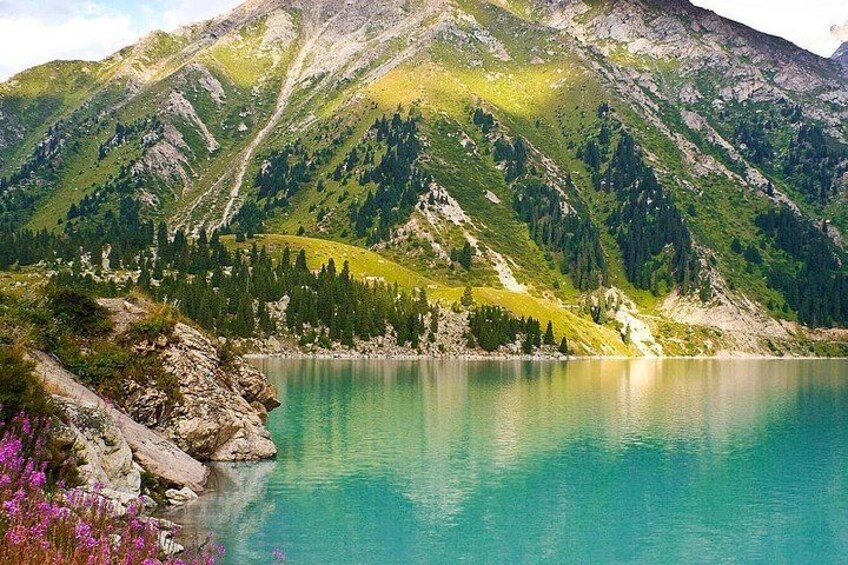 Un lac de montagne entouré de pentes boisées. 1