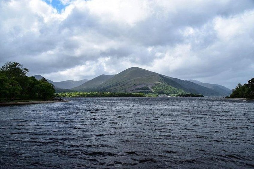 A lake with mountains in the background and trees along the shore. 4