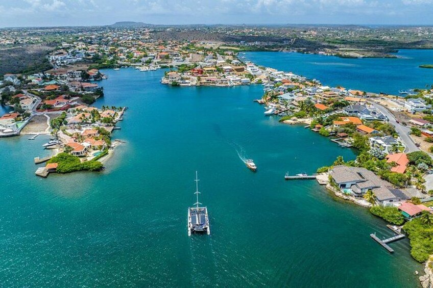 An aerial view of a coastal town with a marina, boats, and houses. 4