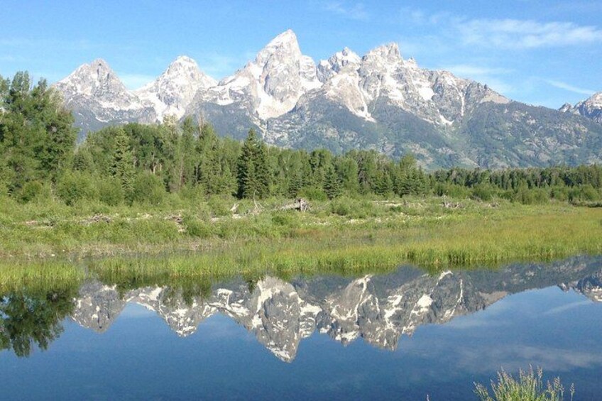 A mountain range with a lake reflecting the peaks. 1