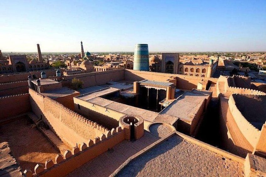 Un paisaje urbano histórico con arquitectura antigua, incluyendo estructuras con cúpulas y murallas fortificadas. 2