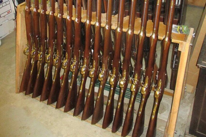 A collection of rifles displayed on wooden racks. 3