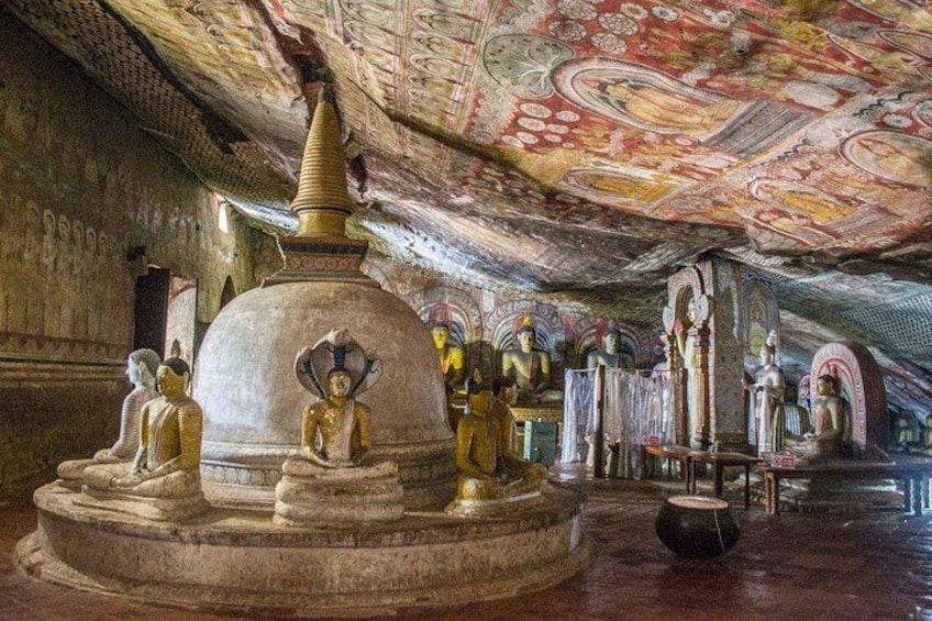 Interior de un templo con una gran estupa, estatuas de Buda sentados y elaborados adornos en el techo. 1