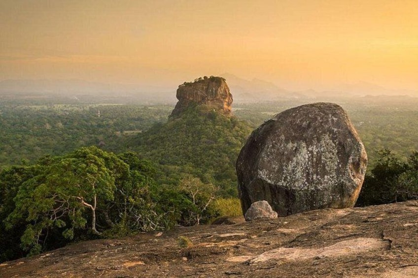 Eine große Felsformation mit einem kleineren Felsen im Hintergrund, umgeben von dichtem, grünem Wald. 5