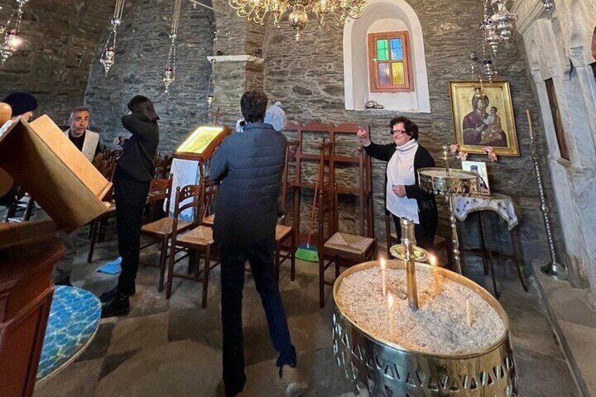 A church interior with stone walls, wooden pews, a chandelier, and a lit menorah. 4