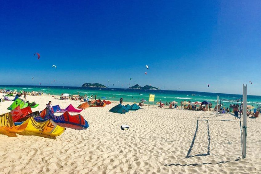 A beach with colorful umbrellas and a volleyball net. 2