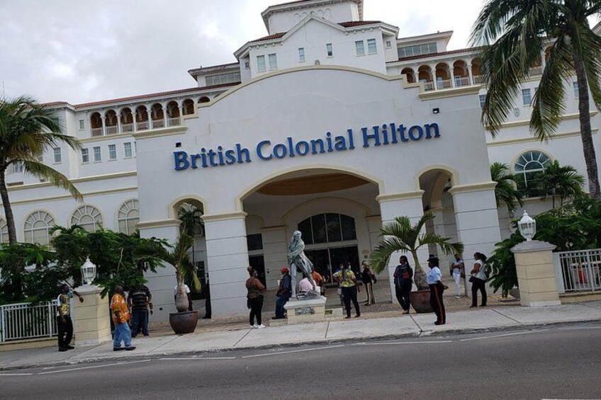 The British Colonial Hilton hotel facade with palm trees and people in front. 5