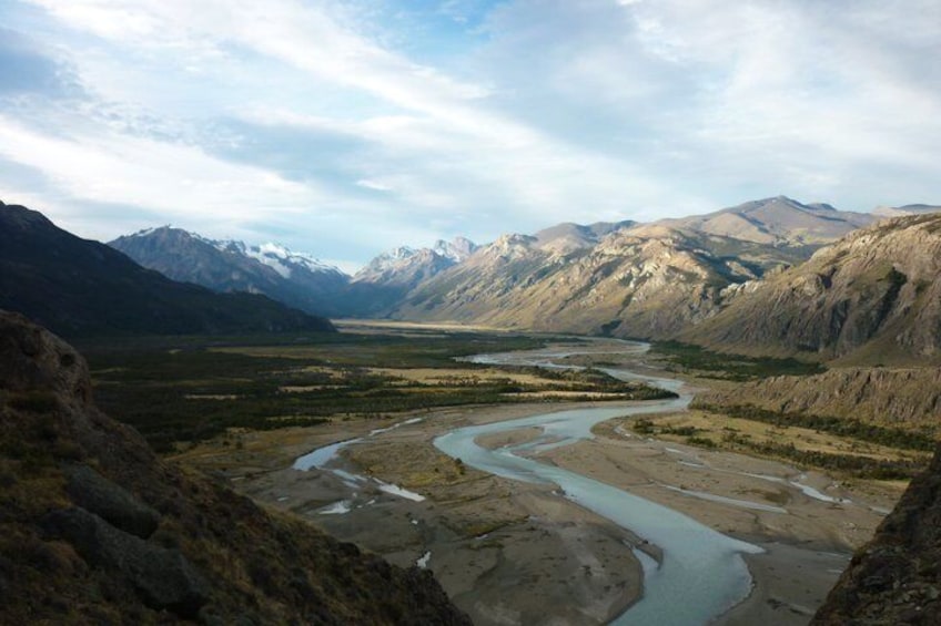 A river winding through a mountainous valley with snow-capped peaks in the background. 2