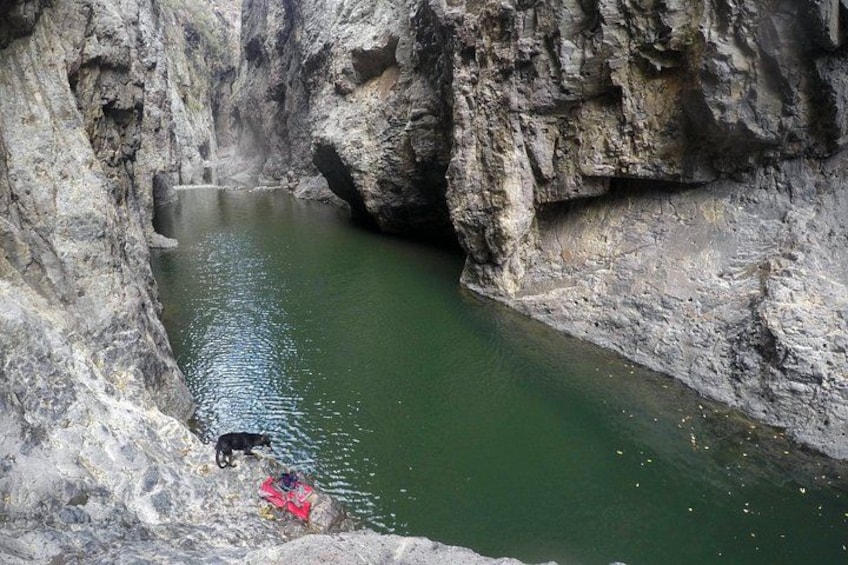 A narrow canyon with a small body of water. 1